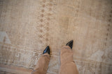 Vintage distressed Oushak carpet with worn pile, sand and beige lattice and flower pattern.