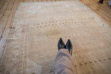 Distressed Oushak carpet showing faint sand and beige lattice patterns with even low pile.