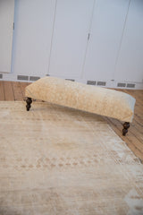 Distressed vintage Oushak carpet, soft sand tones with subtle pawn border pattern.