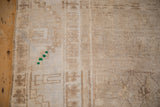 Sand and beige distressed Oushak pile with emerald green detail at the side selvage.