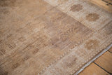 Distressed Oushak rug detail: worn low pile texture with soft coffee brown and ivory tones.