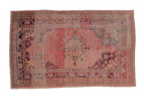 Vintage Distressed Oushak rug with a pink abrashed field, central medallion, and vine and pawn borders. 3'4