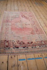 Distressed pile and fringe of a pink Oushak rug with pawn and vine borders.
