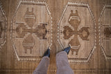 Textured distressed Kars carpet, geometric gul medallions on abrashed coffee brown field.
