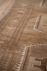 Distressed Kars carpet geometric border with reciprocating wave motif in coffee, ivory.