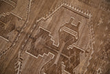 Abrashed field with geometric hook and latch motif on vintage Kars carpet.