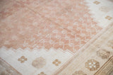Time-softened dusty copper lattice field and ivory border of this vintage distressed Oushak rug.