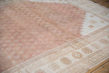 Distressed Oushak rug with running wave border and muted copper lattice field.