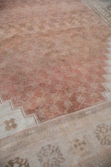 Distressed vintage Oushak rug field with dusty copper abrash and geometric ivory border.