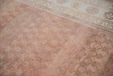 Distressed Oushak rug: heavy abrash on copper lattice field and antique ivory border.