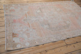 Soft, abrashed texture of a vintage Oushak rug's medallion and borders shown from an angle.