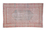 Vintage Distressed Oushak rug with faded ivory field, central turquoise design, and floral borders.