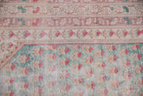Oushak rug detail: pale turquoise field with red boteh and worn floral border.