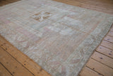 Distressed vintage Oushak rug edge with faded seafoam green and soft raspberry tones.
