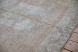 Distressed vintage Oushak carpet close-up, highlighting low pile, subtle geometric patterns, and time-softened hues.