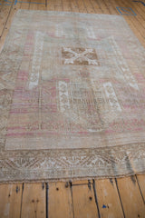 Distressed Oushak rug's frayed fringe and main border, with pale raspberry and camel serrated leaf motifs.