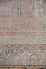 Distressed Oushak rug fringe and camel serrated leaf border detail.