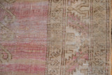 Time-softened pile texture of an abrashed vintage Oushak rug in pale raspberry and camel.