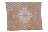 Distressed vintage Oushak carpet, abrashed tan field, faded medallion and checkered borders.