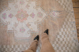 Vintage Oushak carpet with distressed abrashed sandalwood field, faint foundation, and checkered border.