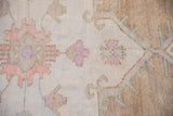 Detail of Oushak carpet with distressed pile, abrashed sandalwood, fuchsia, and ivory tones.