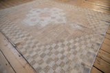 Textured abrashed field of a vintage Oushak rug with a coffee brown checkered border.