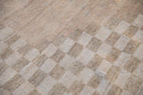 Distressed vintage Oushak carpet's checkered border detail in soft sandalwood and ivory.