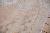 Close-up of vintage Oushak rug's distressed pile texture, abrashed field, and intact selvage.