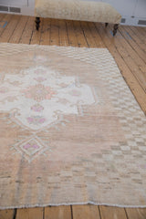 Distressed Oushak corner showing even wear, abrashed field, and pale cantaloupe floral spandrel.