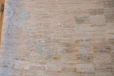 Back of vintage Oushak rug showing faint knot heads and scattered dark marker areas.