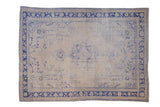 Distressed vintage Oushak rug with faded blue medallion, floral patterns on antique ivory field, 7'9
