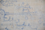 Distressed vintage Oushak rug showing faded blue tribal motifs and worn foundation texture.