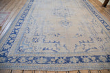 Distressed Oushak carpet corner; cobalt and pale blue worn floral border with fringe.