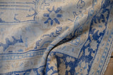 Distressed Oushak rug pile, with worn cobalt and denim blue floral motifs on ivory.
