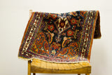 Vintage Persian Bijar rug's folded corner shows colorful tribal patterns and hand-spun wool pile.