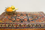 Vintage Persian Bijar rug corner: colorful tribal patterns on dark abrash field.