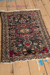 Angled view of a vintage Lilihan rug showing its worn texture and complex floral medallion.
