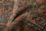 Gently folded antique Kurdish Hamadan rug displays abrashed blues and dusty red Herati motifs.