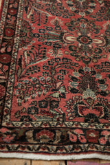 Vintage Dargezine rug corner: faded raspberry field, intricate floral sprays, and navy border.