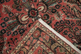 Folded vintage Dargezine rug showing hand-knotted foundation, fringe, and faded red floral pattern.