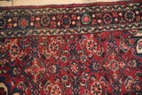 Cherry red, navy blue, ivory geometric border detail of a vintage Hamadan rug, even pile.