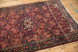 Vintage Hamadan rug's starburst medallion and Herati field, featuring cherry red, cobalt blue, and ivory tones with even pile.