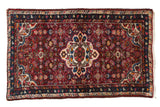 Vintage Persian Hamadan rug with a scalloped medallion on a burgundy red field with Herati design.