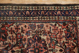 Detail of the vintage Dargezine rug's meandering vine border in cobalt blue and brick red.