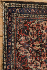 Dark chocolate brown side cord selvage and cobalt blue main border of a vintage Persian Dargezine rug.