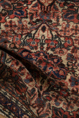 Softly folded vintage Dargezine rug displaying its mostly even pile and detailed floral patterns.