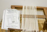 White warp threads tautly strung on the vintage wooden oriental rug loom.