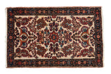 Vintage Borchalou rug with a floral medallion and bouquets in red, blue, and rust over an ivory ground.