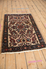 Vintage Borchalou rug with a dense floral pattern on an ivory field, seen from a high angle.