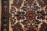 Floral sprays in navy blue and terracotta on an ivory field beside the dark original selvage border.